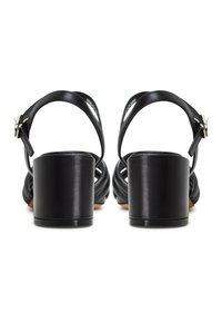 Les sandales en cuir noir présentent un talon carré imposant, une sangle de cheville avec boucle, et un design tissé sur le devant pour un détail texturé.