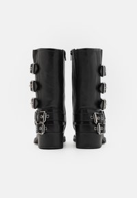 Black leather knee-high boots with a smooth texture, featuring multiple silver buckles and a sturdy block heel. Side zipper for closure.