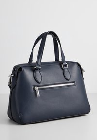 Granatowa skórzana torebka z dwoma górnymi uchwytami, srebrnymi okuciami i przednią kieszenią na zamek. Gładka faktura, usztywniony kształt.