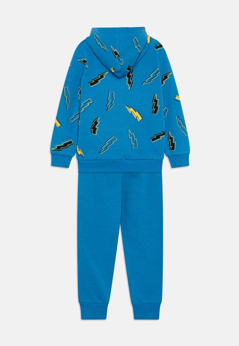Modrý mikinový set s kalhotami se vzorem černých a žlutých blesků. Vyrobeno z měkké látky s elastickými manžetami a pasem.