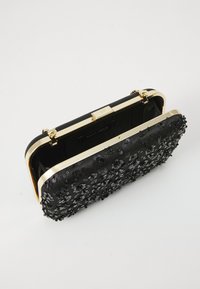 Geantă neagră tip clutch fabricată din material texturat, cu broderii florale din paiete, feronerie aurie și închidere tip kiss-lock.
