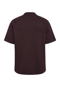 Brun kortärmad t-shirt med rund halsringning, tillverkad av mjukt tyg, med raglanärmar och rak nederkant.