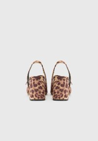 Sandale s platformom s leopard uzorkom, otvorenog stražnjeg dijela i debelim petama, s mekom teksturom i smešano-bež shemom boja.