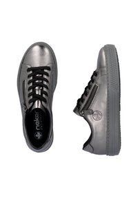 Sneaker grigio metallizzato con lacci neri, cerniere laterali e suole in gomma. Presenta un logo rotondo sul lato e una suola testurizzata.