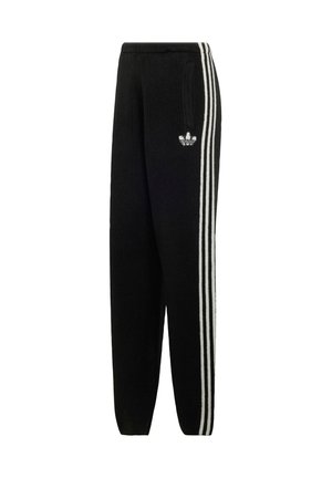 Pantalon de survêtement noir avec trois bandes blanches sur les côtés et un petit logo trefoil Adidas sur la partie supérieure de la jambe gauche.