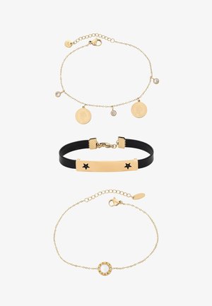 Trzy bransoletki: złoty łańcuszek z monetami i kryształami, czarna opaska z złotą gwiazdką, delikatny złoty łańcuszek z okrągłym wisiorkiem LOVE.