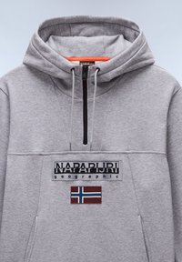 Felpa grigia con cappuccio e chiusura a mezza zip, caratterizzata da un patch del logo nero e un accento della bandiera norvegese. Tessuto morbido e testurizzato.