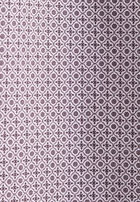 Motif floral et géométrique violet foncé répétitif sur un fond de tissu violet clair, créant un design texturé dense.