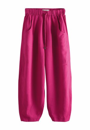 Živé růžové kalhoty se širokými nohavicemi s elastickým pasem, stahovací šňůrkou a předními kapsami, zobrazené na bílém pozadí.