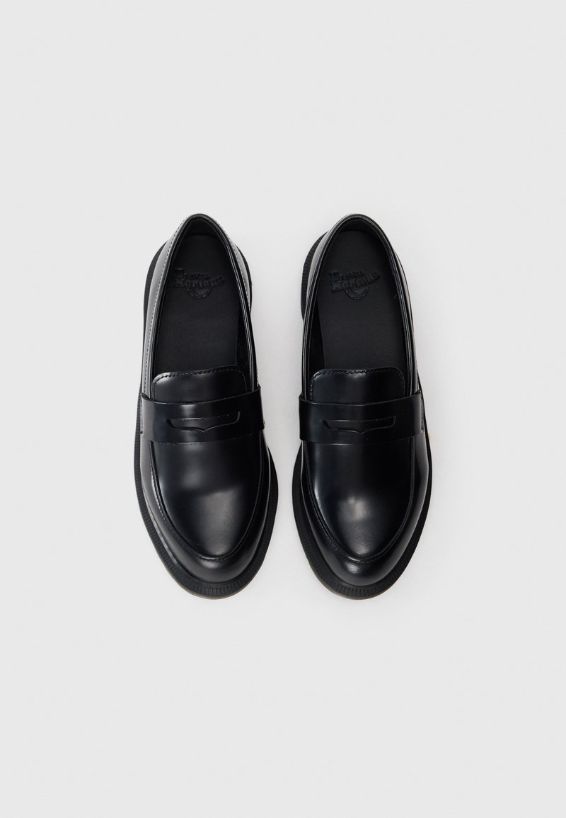 Black leather loafers with a rounded toe and minimal design. Features a flat rubber sole and a leather strap detail across the top.