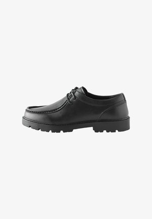 Scarpa da uomo elegante nera in pelle con lacci, suola spessa in gomma con carrarmato, punta arrotondata e cuciture a contrasto su sfondo bianco.