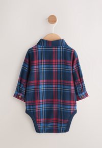 Body bébé à manches longues avec motif à carreaux bleu, rouge et blanc, suspendu à un cintre en bois sur fond blanc.