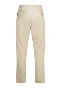 Cream-colored cotton trousers with an elastic waistband, two back pockets, and tapered legs. The fabric has a smooth, soft texture.