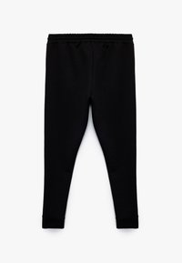 Sorte leggings lavet af et blødt, strækbart stof. Har en samlet elastisk talje og tætsiddende manchetter ved anklerne.