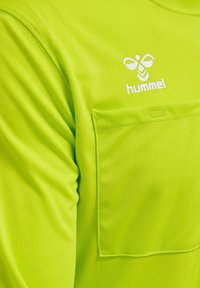 Limegrøn atletisk skjorte med en forlommer, prydet med det hvide Hummel-logo. Fremstillet af glat, let stof med rund halsudskæring.
