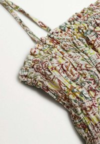 Robe à imprimé floral avec bretelles réglables, présentant une texture froncée et des couleurs variées incluant des motifs verts, jaunes et bordeaux.