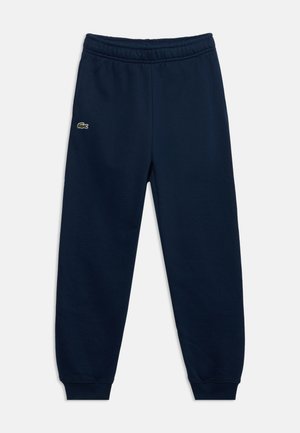 Pantalon de survêtement bleu marine avec ceinture et poignets élastiques, avec un petit logo crocodile vert sur la cuisse gauche.