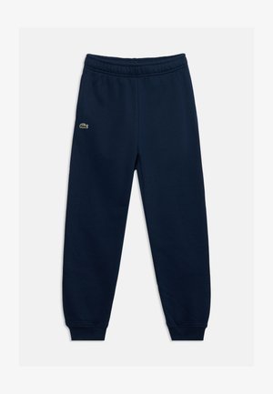 Tmavomodré tepláky s elastickým pásom a manžetami, s malým zeleným logom krokodíla na ľavom stehne.