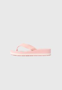 Rosa plattform flip-flop sandal med stripete stoffstropper og en hvit og gråstripet fotseng på en ensfarget bakgrunn.