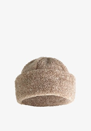 Beige, textured hat made of plush material. Rounded top with a soft, thick cuff. Seamless design without visible fasteners or embellishments.