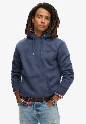 Navy blue hoodie with a front pocket, drawstring hood, and embroidered logo, layered over a checkered flannel shirt, worn with distressed jeans.