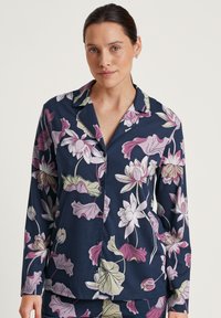 Marine bloemen pyjama set met grote roze en groene lotus ontwerpen, lange mouwen, een notched kraag en een sluiting met knopen aan de voorkant. Zachte stof textuur.