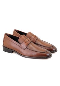 Braune Lederloafers mit glatter Oberfläche, die über ein vorderes Riemendetail und einen niedrigen, flachen Absatz verfügen. Klassisches Design mit minimalen Nähakzenten.