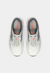 Lightweight running shoes with a gray and white mesh upper, featuring orange accents, textured patterns, and contrasting black soles.