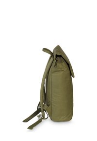 Sac à dos en tissu vert olive de forme rectangulaire, avec des bretelles réglables et une fermeture à rabat. Dispose d'une fermeture éclair latérale et d'une texture douce.