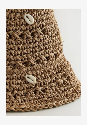 Fonalból készült, világosbarna kalap, texturált anyaggal és fehér csiga kagyló díszítéssel. Kerek karima, nyitott szövésű mintával.