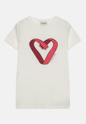 Hvit bomullst-skjorte med et rødt og svart sikksakk hjerte grafikk med overlappende former. Merkenavnet "Lanvin" vises i rosa.