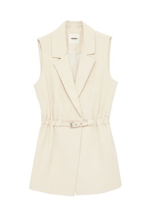 Ærmeløs beige blazer-vest med brede revers og et matchende bælte med metalspænde ved taljen.