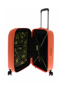 Maleta rígida naranja con un mango retráctil, interior negro con diseño gráfico amarillo, correas negras y compartimento con cremallera.