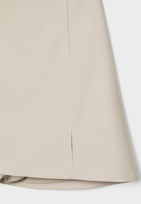 Beige nederdel med et rent design, glat tekstur og en lille sideslids. Materialet virker holdbart og har en skræddersyet finish.