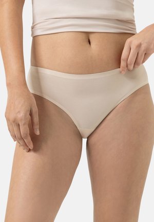 Beige puuvillaiset alushousut, joissa on sileä pinta, keskipitkä vyötärö ja pehmeä joustava vyötärönauha, esitettynä neutraalissa taustassa.