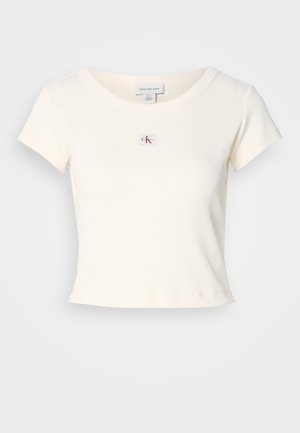 Hvit ribbestrikket t-skjorte med korte ermer, rund hals og et lite CK-logoemerke på brystet. Stoffet ser mykt og tettsittende ut.