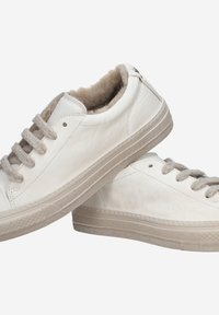 White leather sneakers with gray laces, soft fur lining, flat beige rubber soles, and subtle stitching details.
