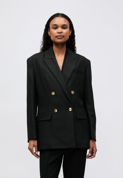 Černý dvouřadý blazer s texturovaným povrchem, zdobený zlatými kulatými knoflíky a jednou náprsní kapsou, navržený v uvolněném střihu.