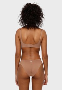 Braunens Lingerie-Set aus strukturiertem, glattem Material. Der BH hat verstellbare Träger und einen Haken- und Ösenverschluss; die Shorts sind mit niedriger Taille.