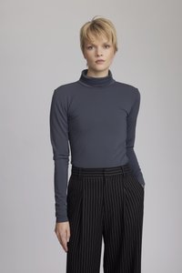Mörkgrå långärmad polotröja i tyg som matchas med svarta byxor med smalrand. Tätt sittande, slät yta och elegant design.