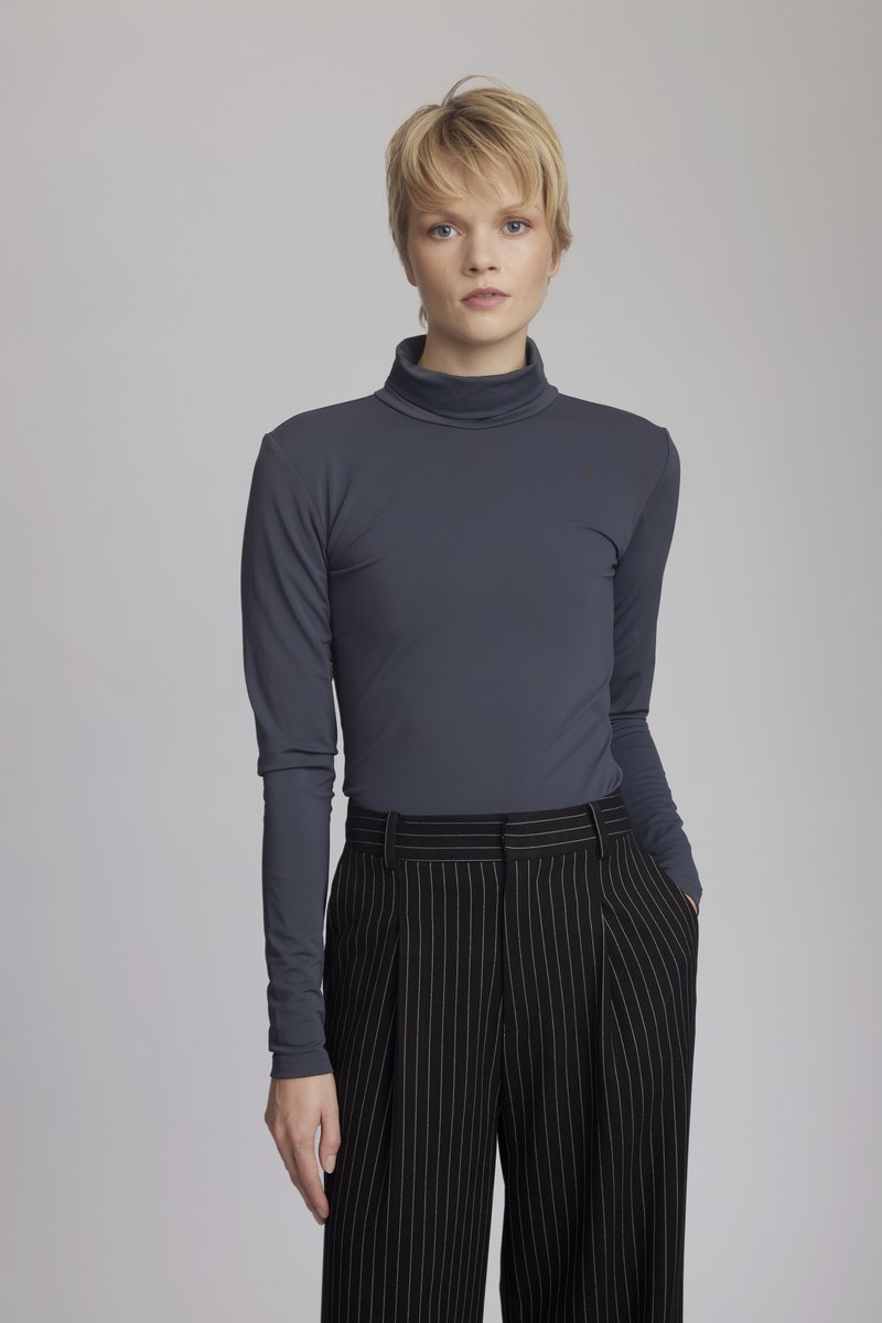 Mörkgrå långärmad polotröja i tyg som matchas med svarta byxor med smalrand. Tätt sittande, slät yta och elegant design.