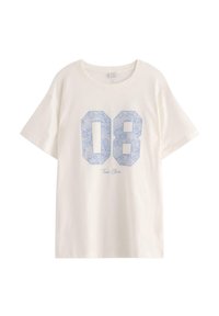 Creme kortærmet t-shirt med blå blonder-mønstrede tal "08" og teksten "Tres Chic" nedenfor. Lavet af bomuldsmateriale med en afslappet pasform.