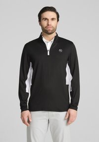 Schwarzer Pullover mit langen Ärmeln, einem halben Reißverschlusskragen und weißen Seitenakzenten. Er verfügt über ein Logo auf der Brust und ist aus einem glatten, leichten Stoff gefertigt.