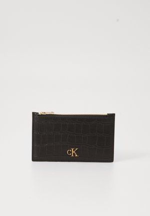 Black crocodile-texture cardholder with gold zipper and gold CK logo on front against white background.