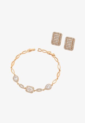 Brățară aurie cu zale marquise alternative și pietre clare mari, asortată cu cercei dreptunghiulari din aur cu ținte încrustate cu pietre clare mici.