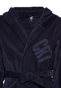 Dunkelblauer Cord-Bademantel mit einem Gürtel in der Taille. Verfügt über eine Kapuze und ein gesticktes "CR7"-Logo auf der Vorderseite. Weiche Textur, mittellange Länge.