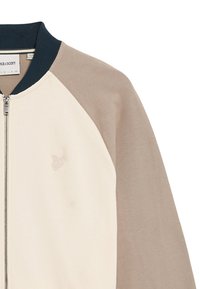 Bomberjakke i creme, beige og marineblå; har raglanærmer, lynlås foran og diskret logo broderi på brystet. Blødt bomuldsblandingsmateriale.