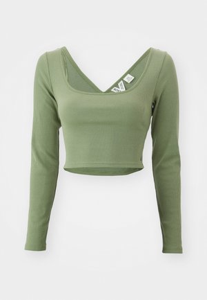 Khaki green, long-sleeve cropped top with a ribbed texture and a wide neckline. Tags visible at the collar.
