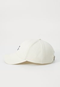 Vit bomull baseballkeps med böjd skärm, broderad text framtill och en metallspänne bak för justerbar passform.