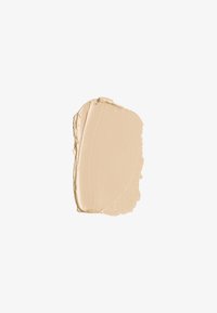 Beżowy produkt przypominający krem o gładkiej, lekko błyszczącej teksturze, charakteryzujący się zaokrąglonym kształtem i równomiernym, spójnym nałożeniem koloru.